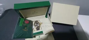 A Gold-Tone Rolex Watch With a Grey Strap