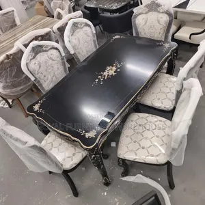 Rococo-Style Black Dining With Floral Accents and Upholstered Chairs.