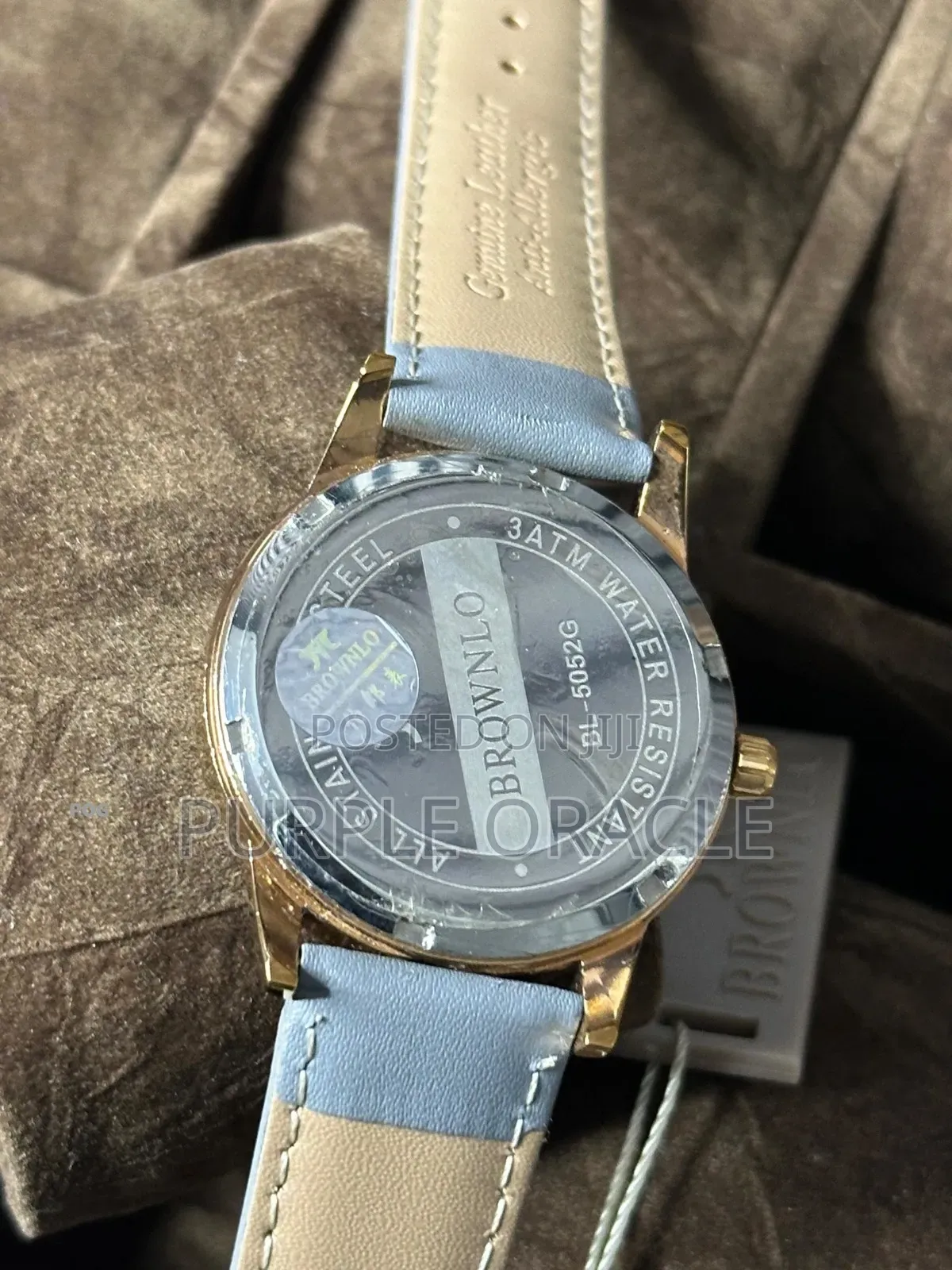 Brownlo Quartz Watch With A White Dial And Light Blue Leather Strap.