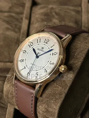 Brownlo Quartz Watch With A Gold-tone Case And A Brown Leather Strap.