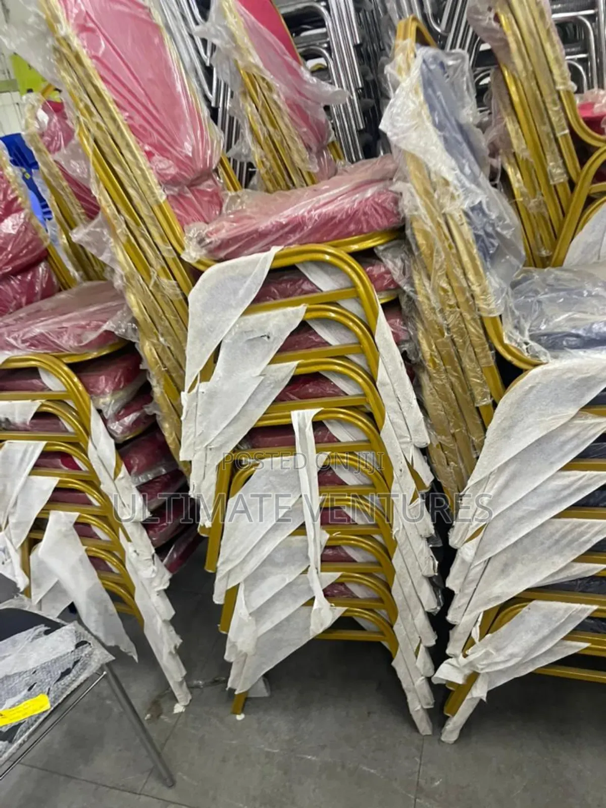 Stacked Gold Frame Banquet Chairs With Red Cushions