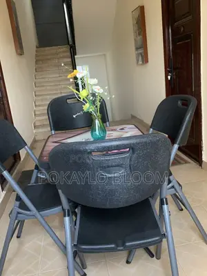 Table With a Decorative Glass Top With 4 Kinds of Folding Chairs.