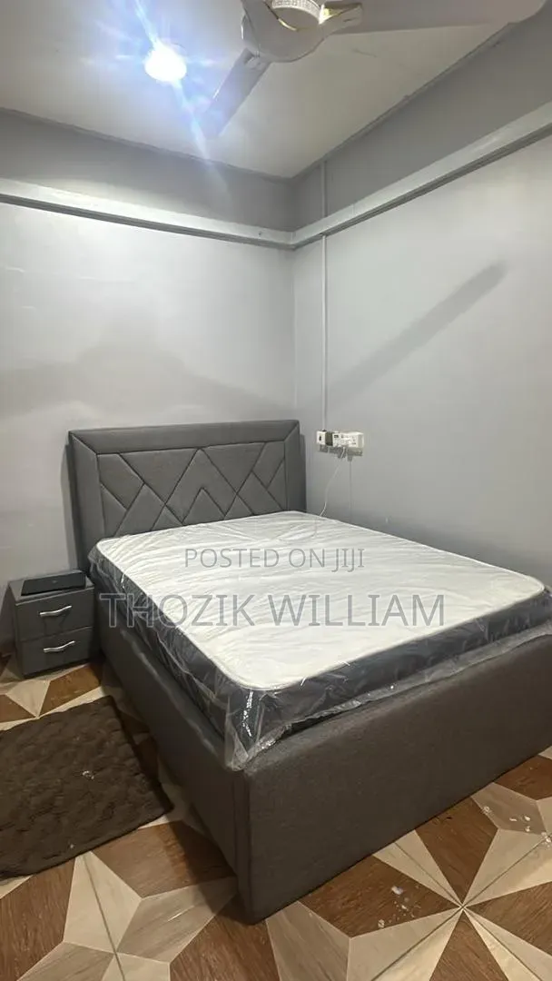 A Double Bed Frame With Mattress and Side Table