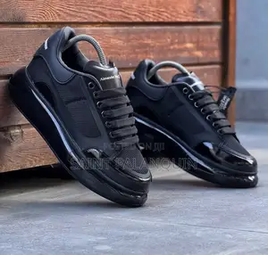 Black McQueen Low-Top Sneaker Wih a Thick Ridged Sole and a Mesh Upper