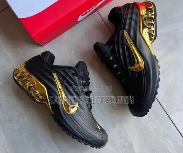 A Black Nike Sneaker With a Glossy Upper and a Metallic Gold Swoosh