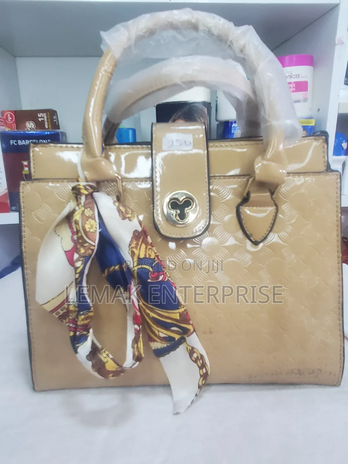 Beige Embossed Patent Leather Top-Handle Handbag With Scarf.