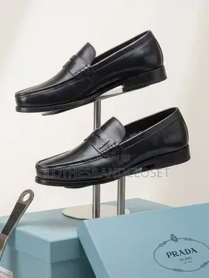 A Pair of Black Leather Penny Loafers Featuring a Keeper Strap