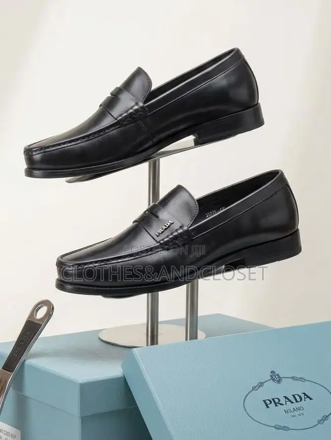 A Pair of Black Leather Penny Loafers Featuring a Keeper Strap