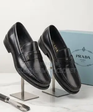 A Pair of Black Leather Penny Loafers Featuring a Keeper Strap