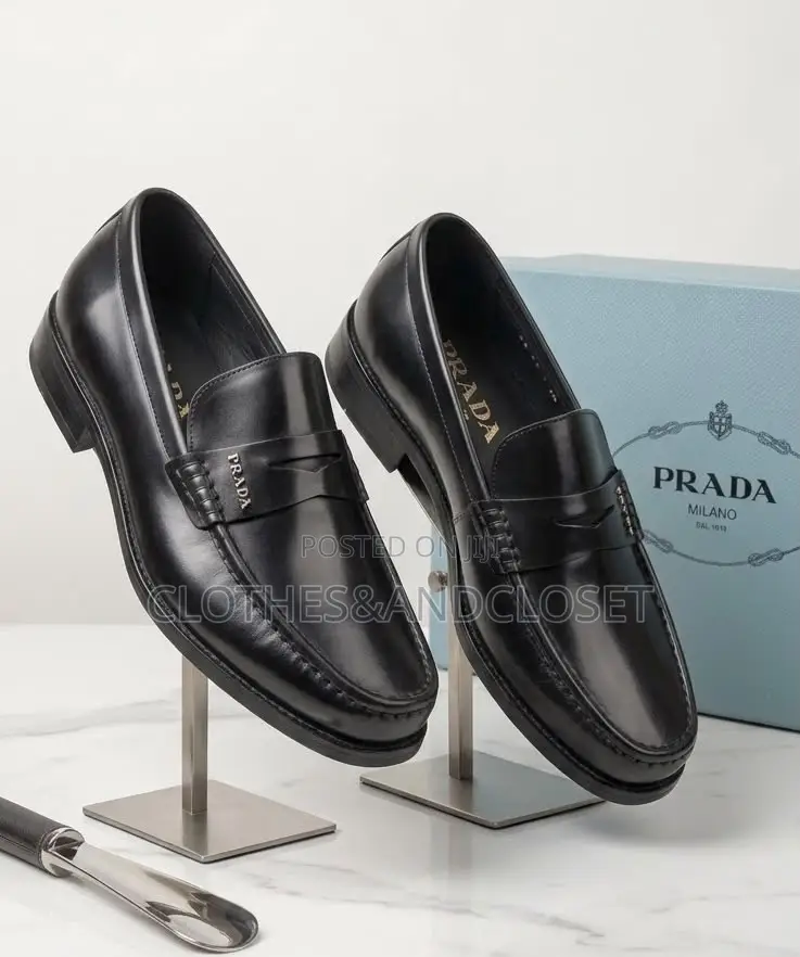 A Pair of Black Leather Penny Loafers Featuring a Keeper Strap