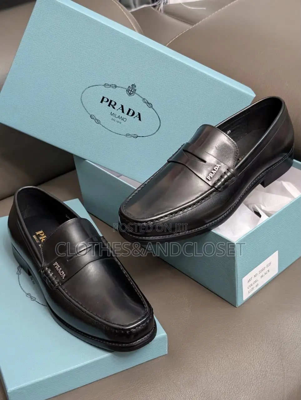 A Pair of Black Leather Penny Loafers Featuring a Keeper Strap