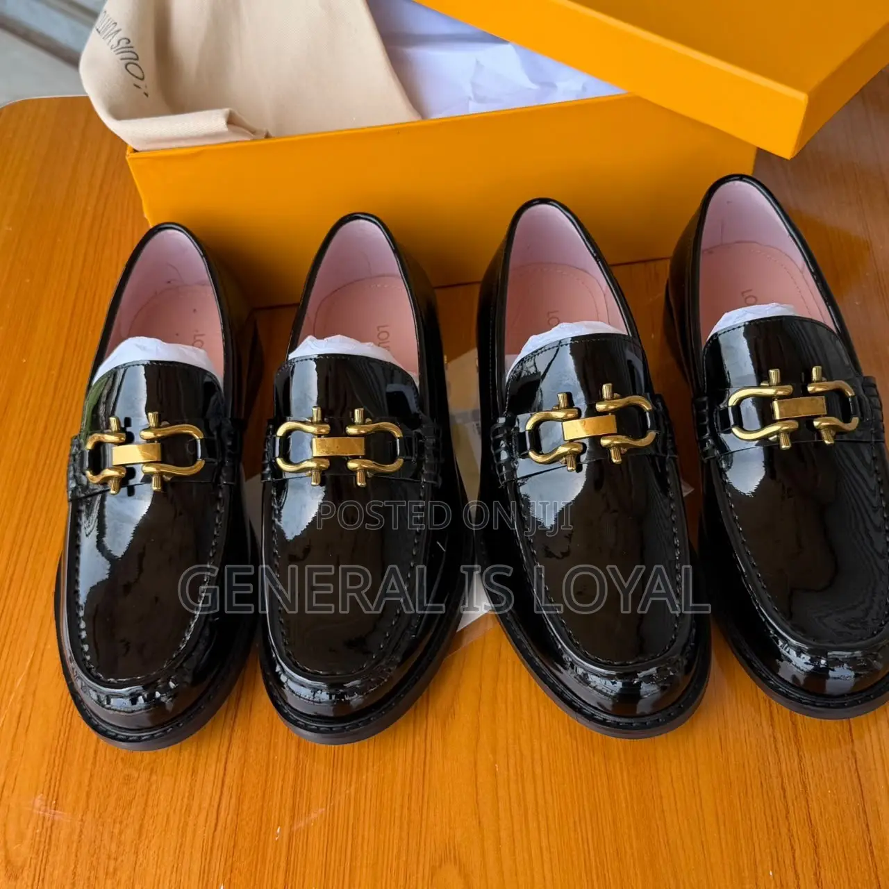 Black Patent Leather Loafers Mirror a Gold-Tone Metallic Buckle